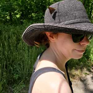 Danielle Bastien wearing a black sunhat with a butterfly landed on it
